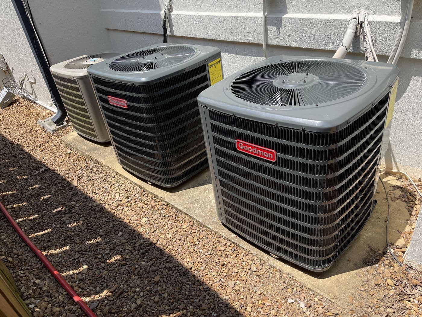 Homeowner's phone camera: three outdoor condensers beside the house