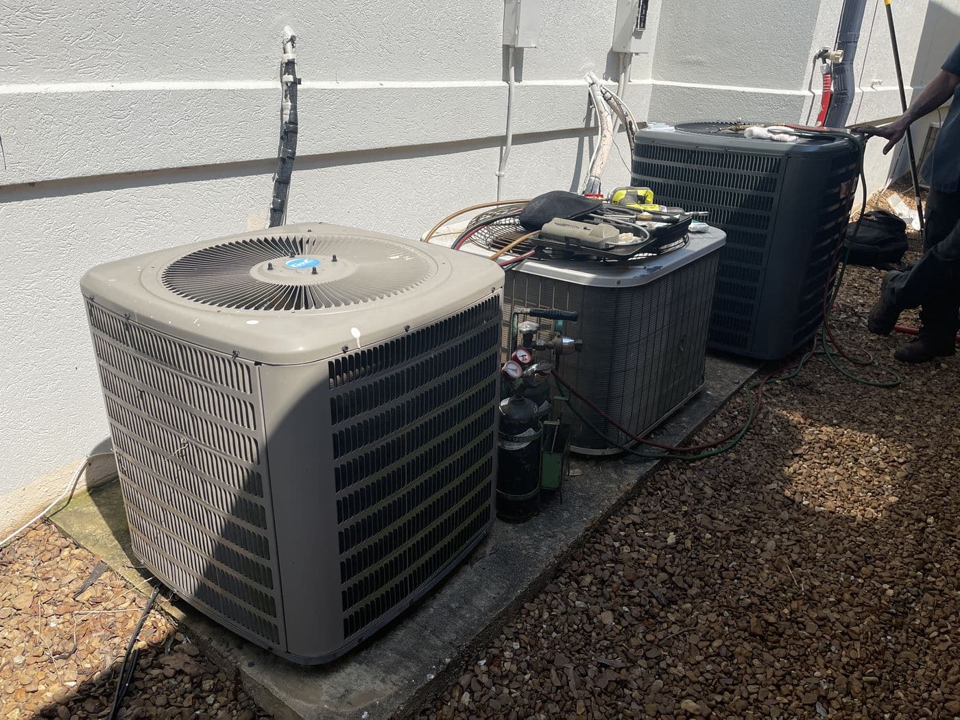 Homeowner's phone camera: technician checking the outdoor condenser with gauges